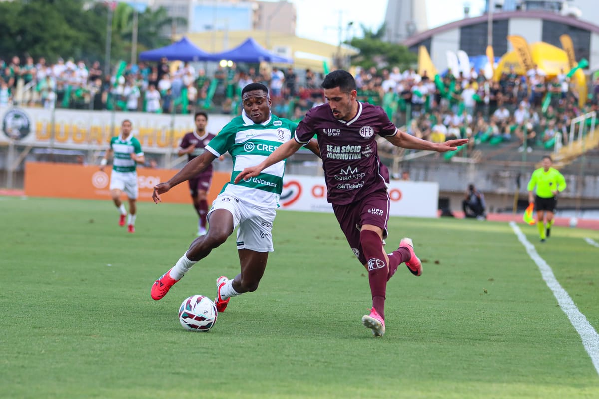 Jogador da Ferroviária, de camisa grená, disputa a bola com um adversário do Maringá, de camisa listrada verde e branca, no gramado do Willie Davids