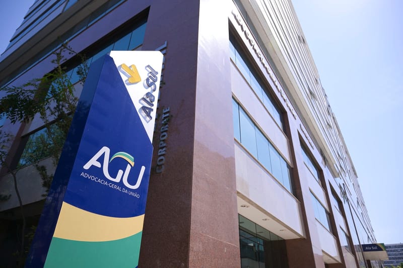 Totem azul e verde com a marca da Advocacia-Geral da União em frente ao prédio da sede, em Brasília