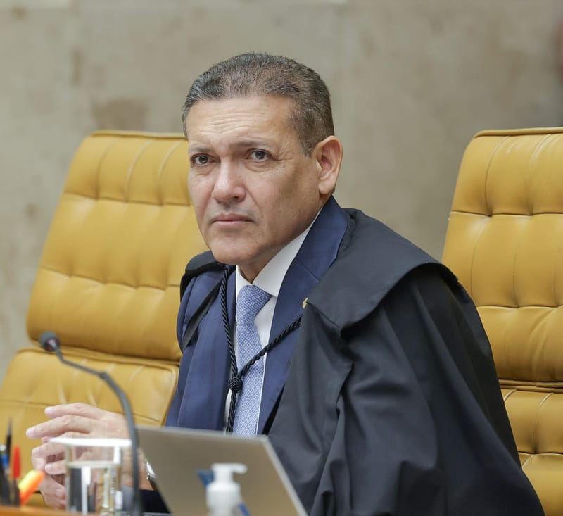 Kassio Nunes Marques, de toga, sentado em poltrona amarela durante sessão plenária, com um notebook à frente