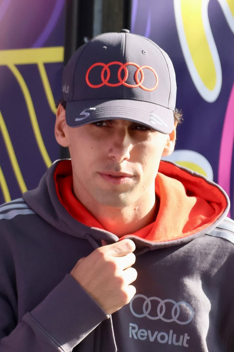 Gabriel Bortoleto, de boné e agasalho da Audi, olha para a câmera no paddock
