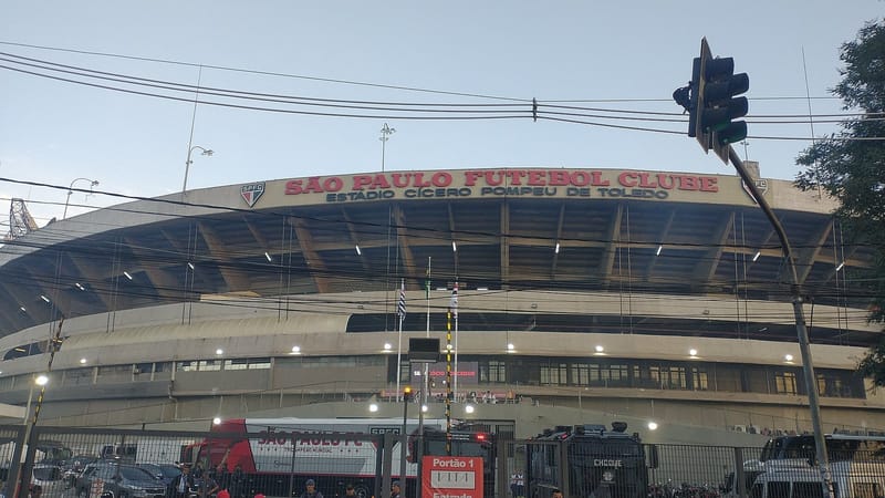 Fachada do Estádio do Morumbis com a inscrição São Paulo Futebol Clube, vista da rua, sob céu claro
