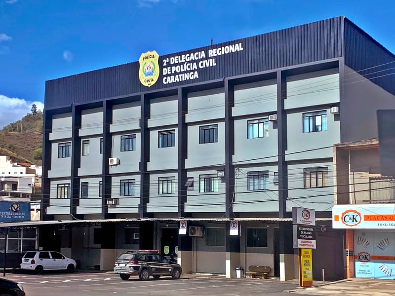 Fachada da 2ª Delegacia Regional de Polícia Civil de Caratinga (MG), com brasão e uma viatura na frente