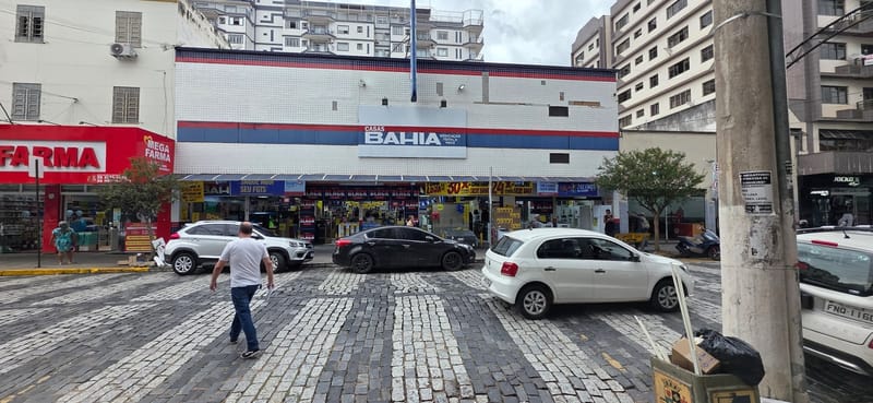 Fachada de uma loja da Casas Bahia, com o letreiro azul e vermelho sobre o prédio, vista da rua