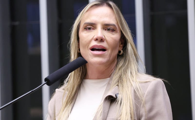 Celina Leão, de cabelo loiro comprido e blazer bege, fala ao microfone