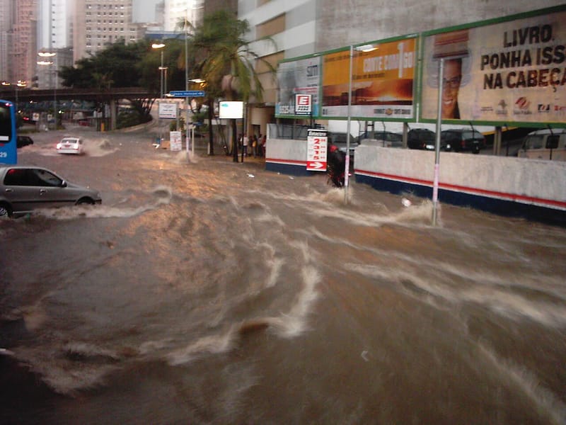 Avenida alagada por enxurrada em São Paulo, com carros atravessando a água (foto de arquivo, 2005)