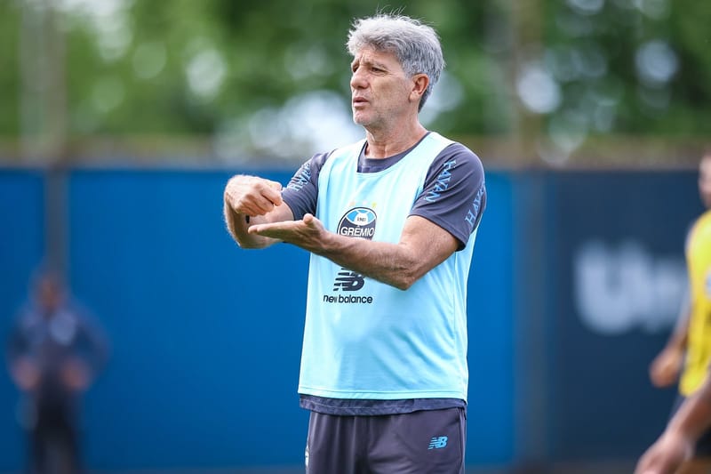 Renato Portaluppi, de colete azul-claro com o escudo do Grêmio, gesticula durante treino em gramado