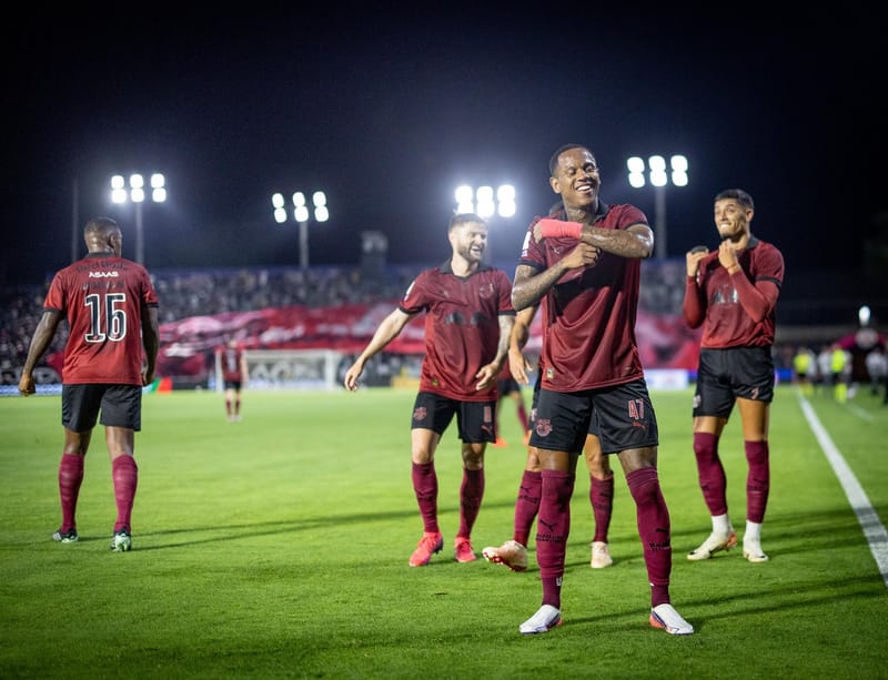 Jogadores do Red Bull Bragantino, de camisa grená, comemoram gol no gramado à noite, em jogo do Brasileirão contra o Cruzeiro