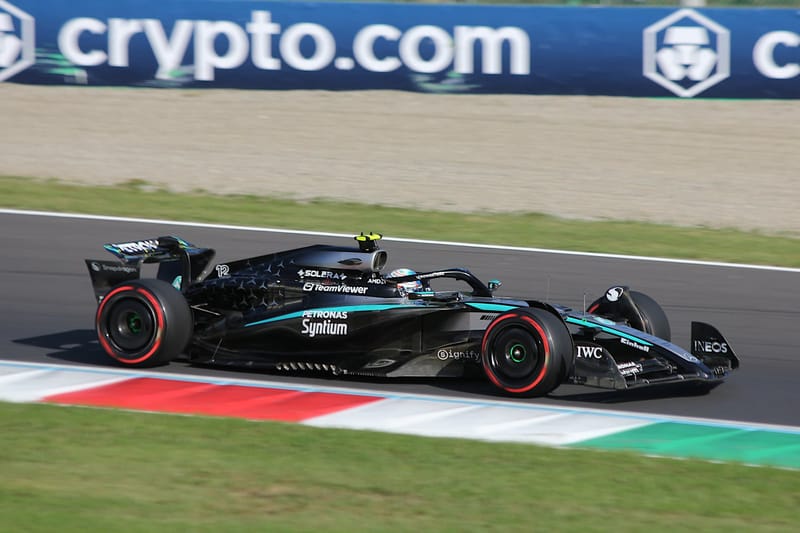Carro preto da Mercedes de Fórmula 1, pilotado por Kimi Antonelli, em curva de pista com zebras coloridas