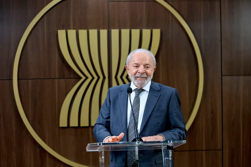 O presidente Luiz Inácio Lula da Silva fala em um púlpito de acrílico, diante de um painel de madeira com o símbolo da Asean