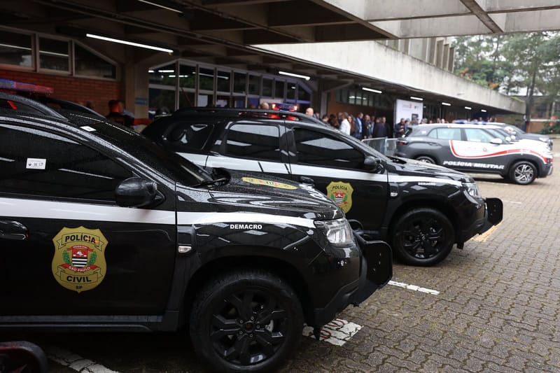 Viaturas pretas da Polícia Civil de São Paulo estacionadas lado a lado, com o brasão da corporação na porta