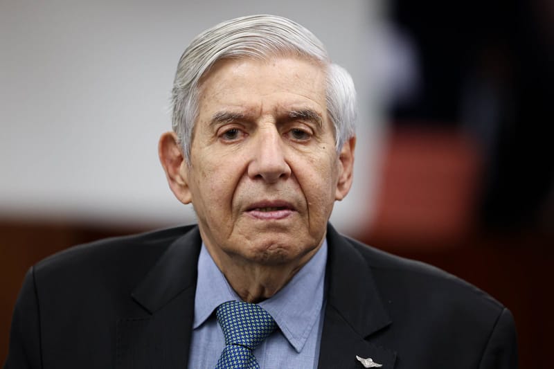 Augusto Heleno, de cabelos brancos, terno escuro, camisa azul e gravata verde, olha para a frente em sala do STF