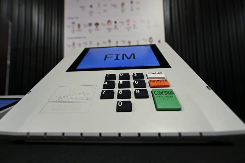 Urna eletrônica da Justiça Eleitoral vista de perto, com o teclado numérico e a tela azul que mostra a palavra FIM