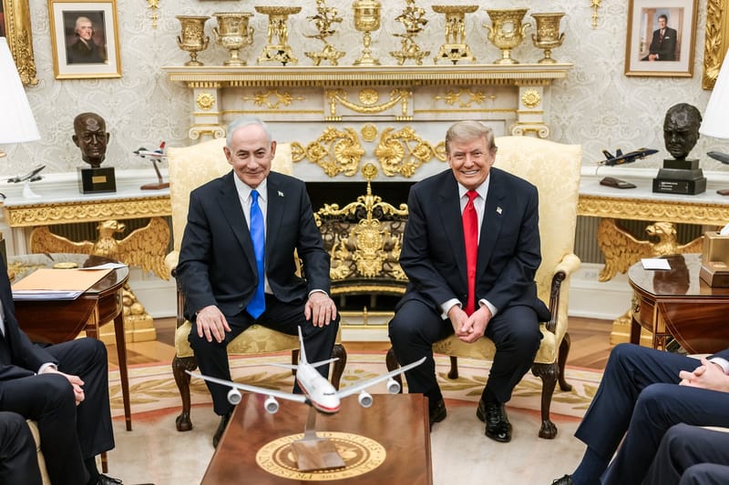 Benjamin Netanyahu, de terno escuro e gravata azul, e Donald Trump, de gravata vermelha, sentados lado a lado em poltronas douradas no Salão Oval