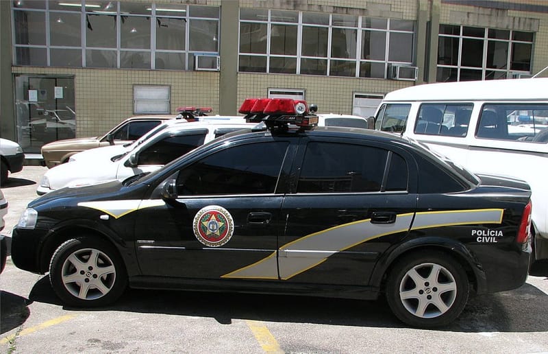 Viatura preta da Polícia Civil do Rio de Janeiro estacionada ao lado de um prédio da corporação