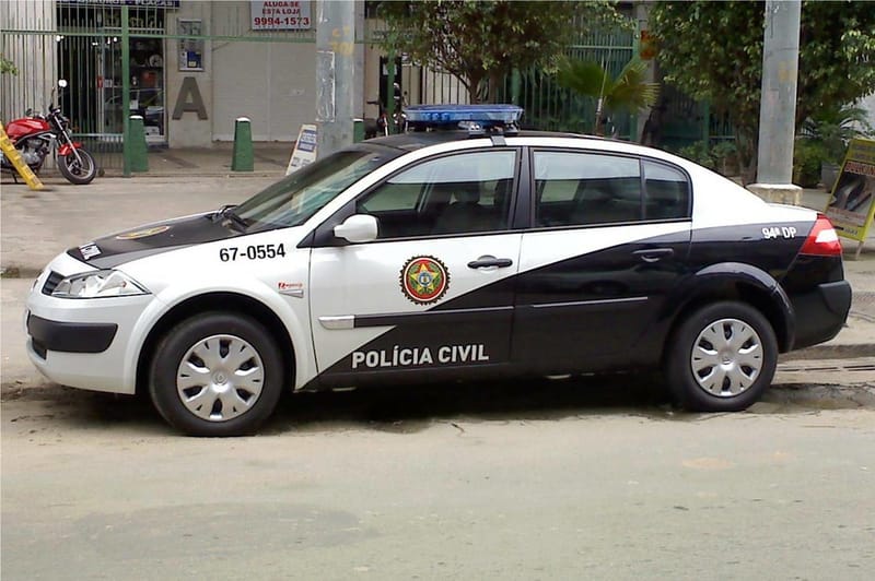 Viatura preta e branca da Polícia Civil do Rio de Janeiro estacionada em uma rua, com o brasão da corporação na porta