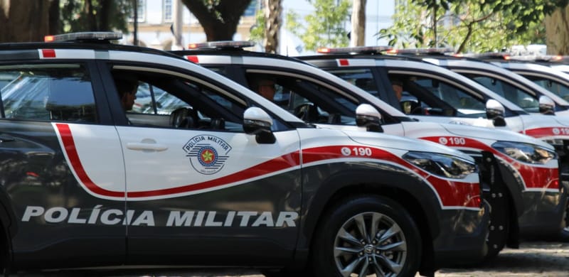 Fileira de viaturas cinza, brancas e vermelhas da Polícia Militar de São Paulo, com o número 190 na porta