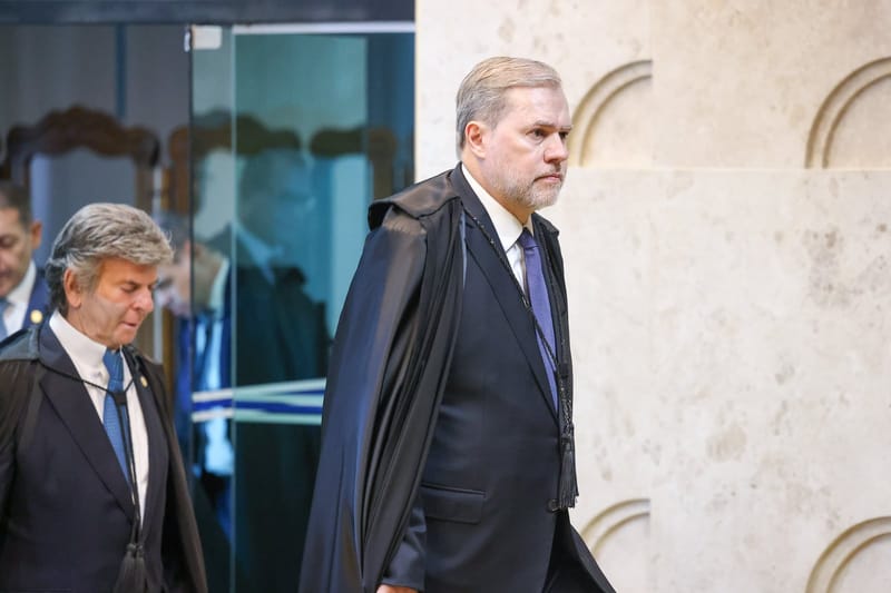O ministro Dias Toffoli, de toga, caminha em direção ao plenário do Supremo; atrás dele, à esquerda, o ministro Luiz Fux
