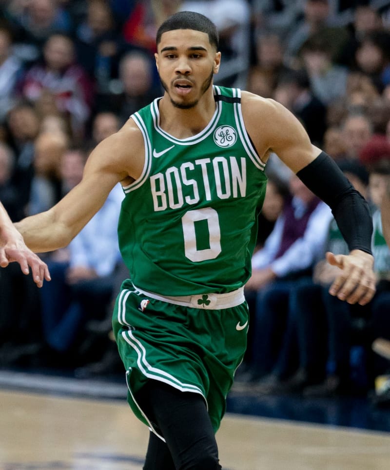 Jayson Tatum, com a camisa verde número 0 do Boston Celtics, avança em quadra durante partida da NBA