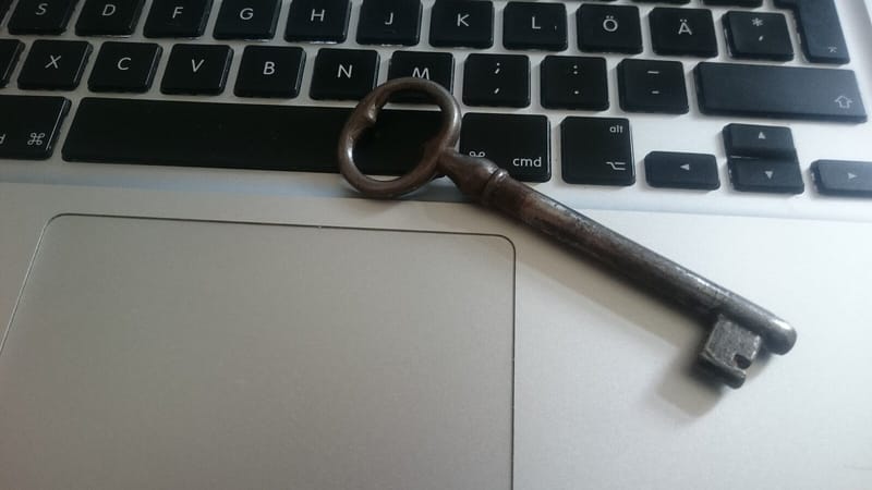 Chave antiga de metal apoiada sobre o teclado de um notebook prateado