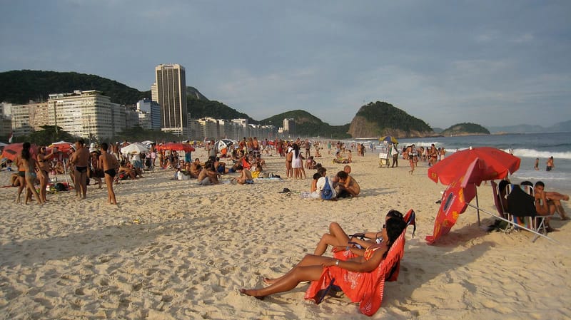 Pessoas aproveitam os últimos raios de sol do dia na praia de Copacabana, no Rio de Janeiro