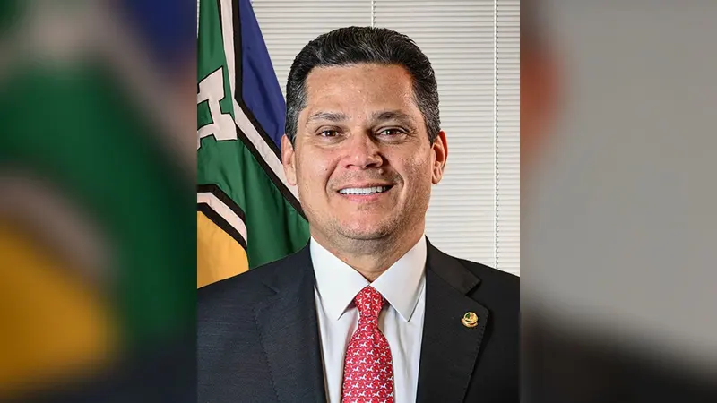 Retrato oficial do senador Davi Alcolumbre, presidente do Senado, diante da bandeira do Amapá