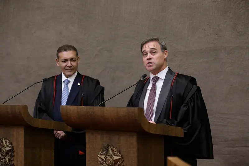 O ministro André Mendonça, de toga preta, fala ao microfone no púlpito do TSE