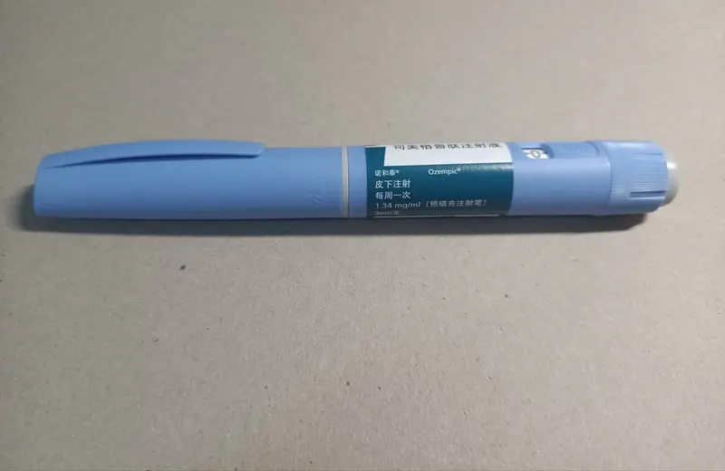 Caneta injetável azul de Ozempic com rótulo em chinês sobre superfície de papelão