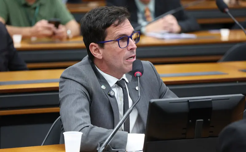 Deputado Luiz Lima, relator da proposta, fala ao microfone em reunião de comissão da Câmara