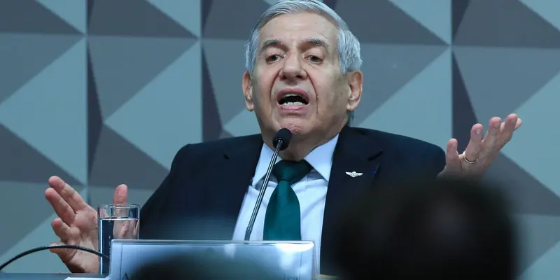 Augusto Heleno, de terno escuro e gravata verde, gesticula ao falar ao microfone durante depoimento no Congresso