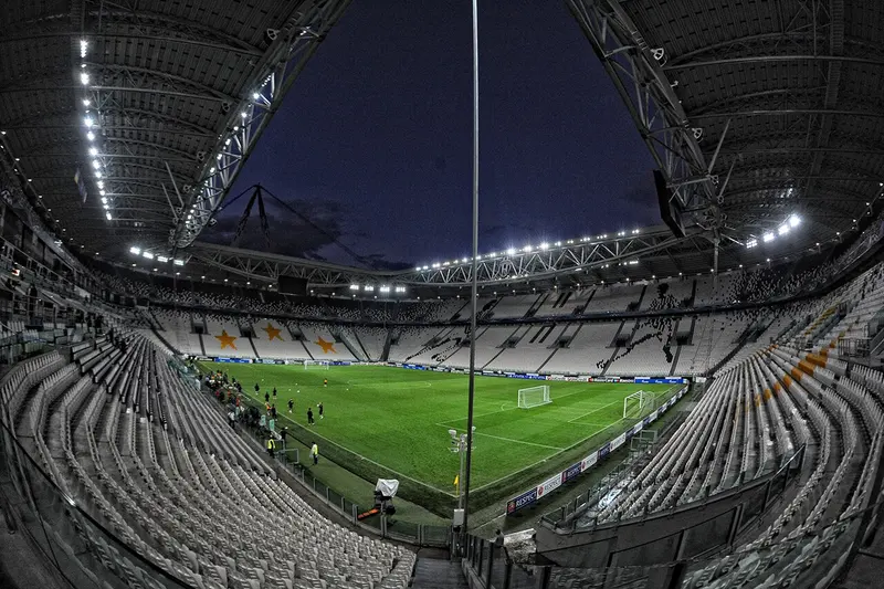 Arquibancadas e gramado do estádio da Juventus, em Turim, iluminados à noite