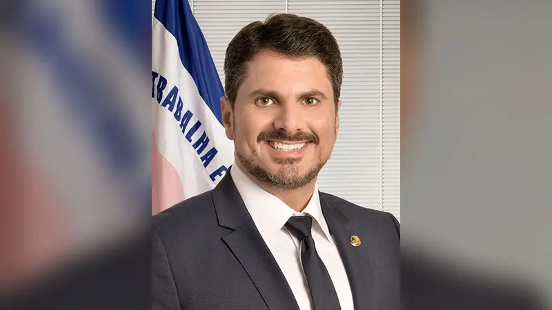 Retrato oficial do senador Marcos do Val, de terno escuro, diante da bandeira do Espírito Santo