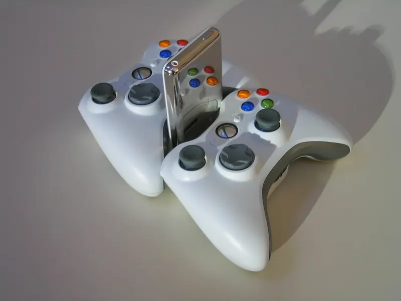 Dois controles brancos de videogame apoiados em uma mesa