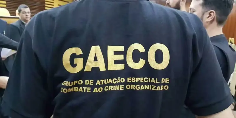Agente de costas veste camiseta preta do Gaeco, grupo de combate ao crime organizado